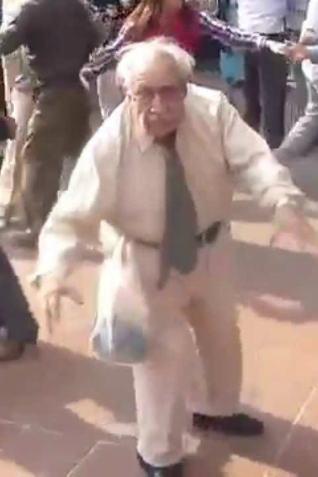 Smieklīgs vecs vīrietis ir savas dzīves laiks, dejojot pūlī